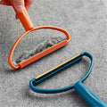 Portable lint remover with long handle, demonstrating its dual fabric brush and copper blade.