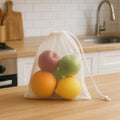 Transparent mesh storage bag holding fresh fruits and vegetables