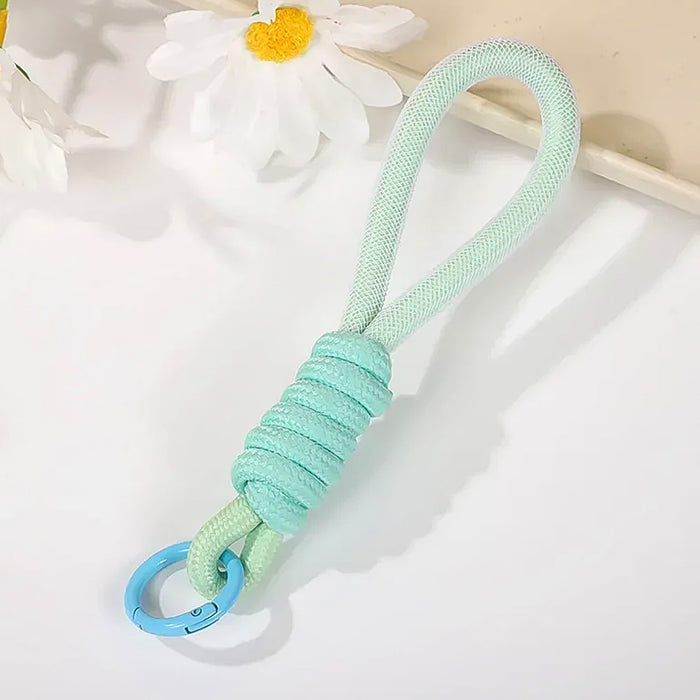 Various uses of the multipurpose strap, including attaching to keys and a camera, showcasing versatility.