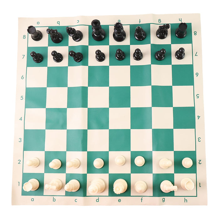 Plastic chess set pieces arranged on the roll-up green and white chess board