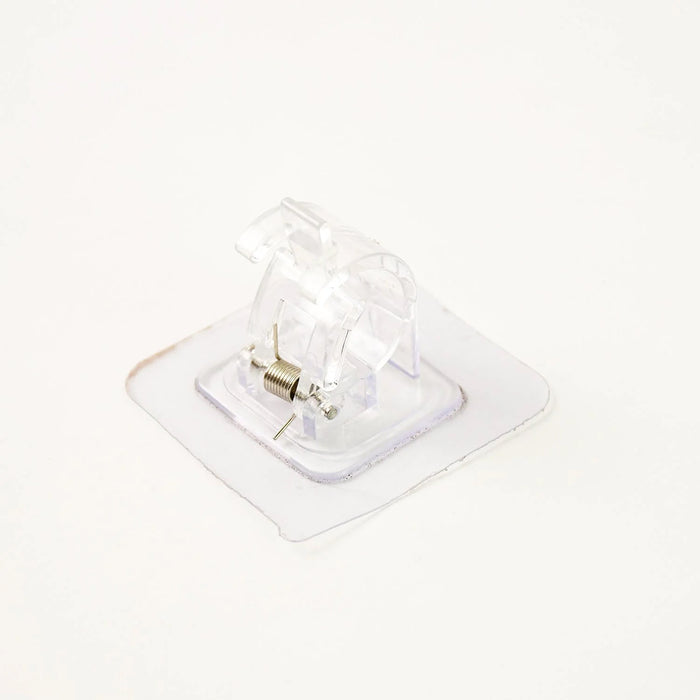 Self-adhesive curtain rail clip installed on wall for lightweight curtains