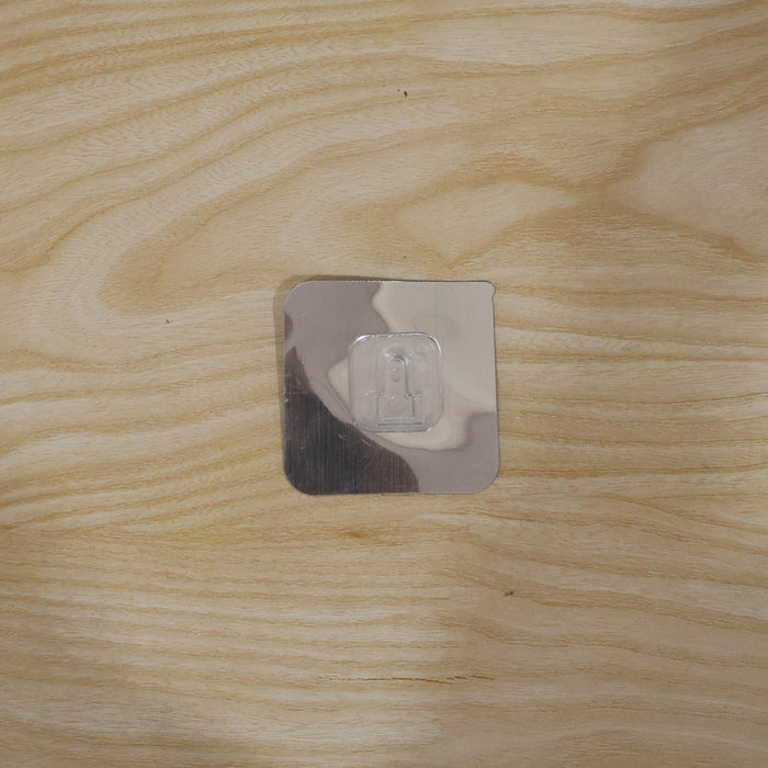 Self adhesive wall hook securely holding items in a home setting.