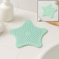 Mint green silicone star shaped sink strainer placed on bathroom sink drain