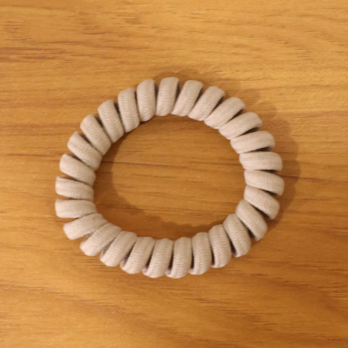 Multiple spiral coil hair bands in assorted shades, offering versatile styling.