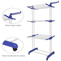 Foldable stainless steel clothes drying rack with wheels and side hanger arms holding garments indoors
